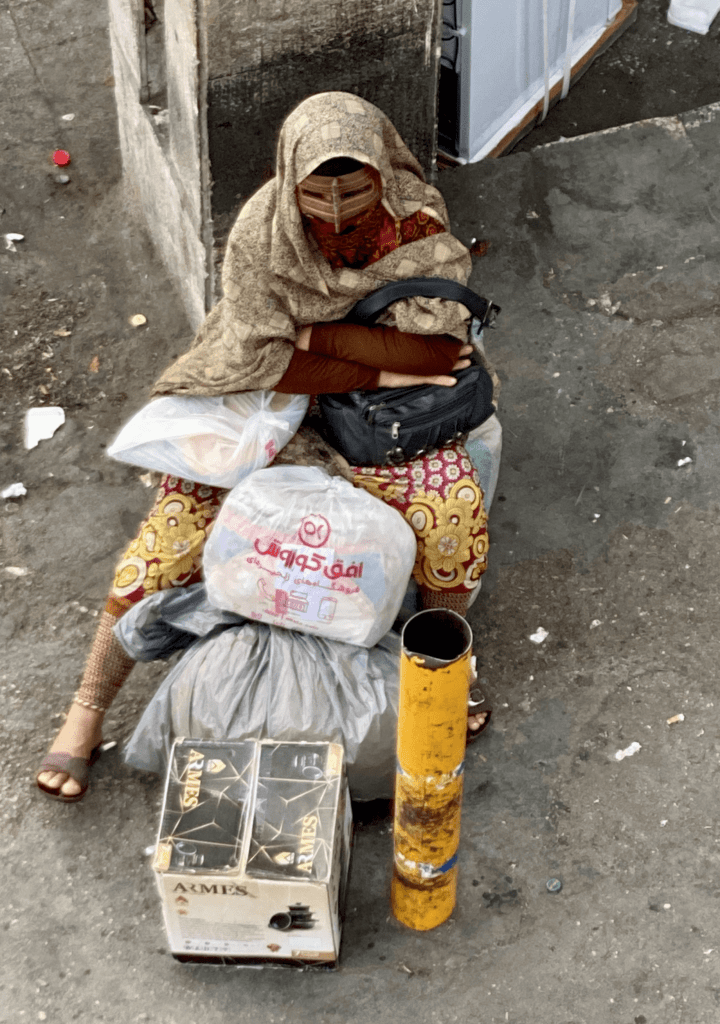 A village woman waits to set up her stall in the afternoon